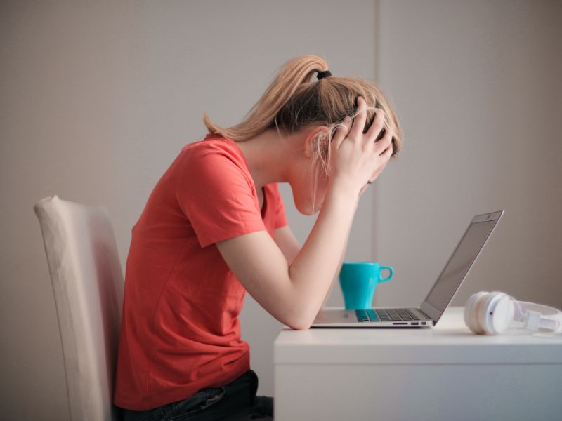 Stressed woman sitting at her desk with her head in her hands